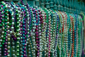 mardis gras beads on a wrought iron fence