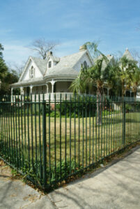 fenced in house with large yard and wraparound porch